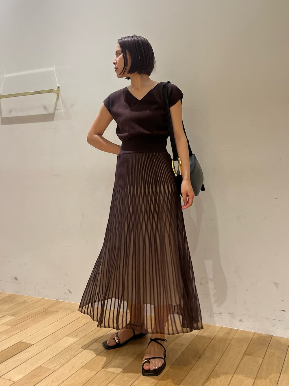 ブラック系のサンダル、ブラウン系のワンピース、ブラック系のショルダーバッグを着用したレディースの夏コーディネートの1枚目の写真