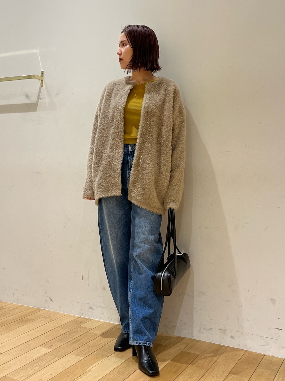 ブラック系のショルダーバッグ、ブラウン系のカーディガン/ボレロ、イエロー系のTシャツ/カットソーを着用したレディースの秋コーディネートの1枚目の写真