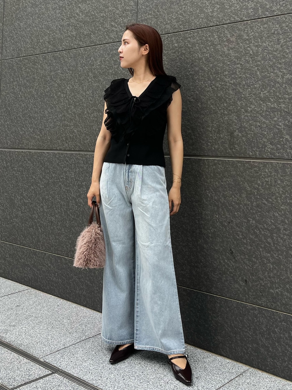 ブラック系のニット/セーター、ブルー系のデニムパンツ、ベージュ系のボストンバッグを着用したレディースの夏コーディネートの1枚目の写真