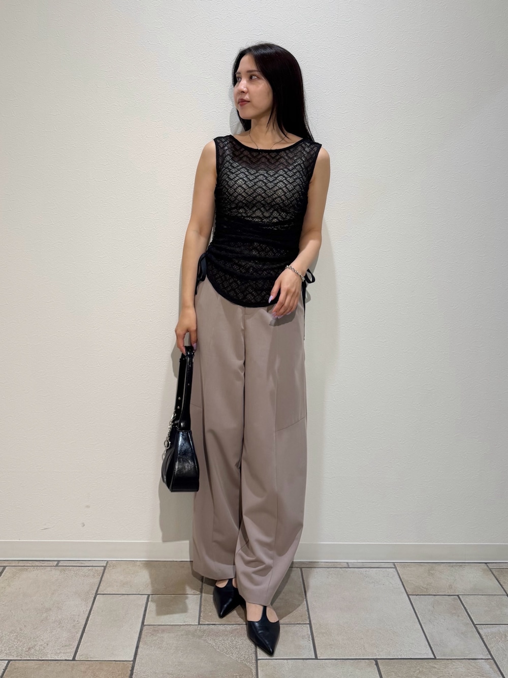 ブラック系のシャツ/ブラウス、ベージュ系のその他パンツ、ブラック系のハンドバッグを着用したレディースの夏コーディネートの1枚目の写真