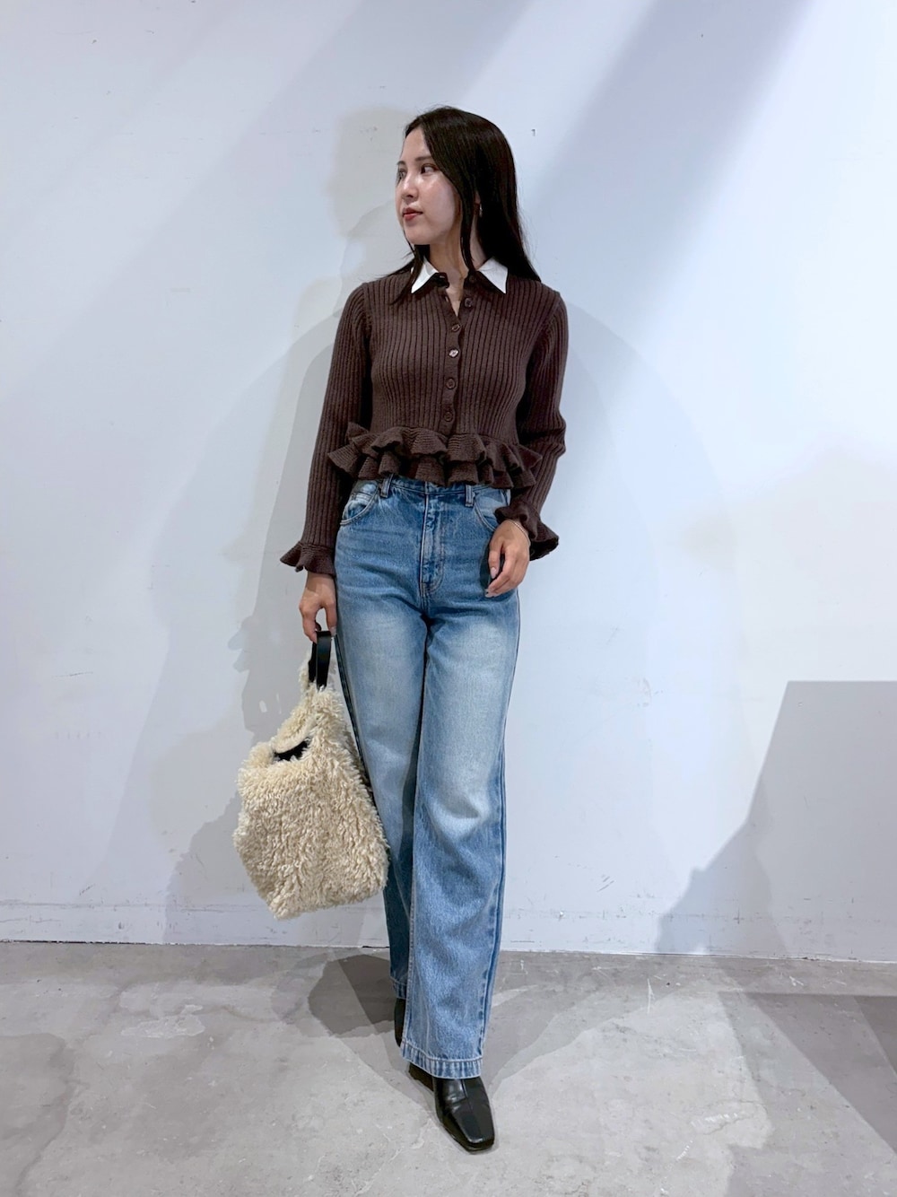 ブラウン系のニット/セーター、ブルー系のデニムパンツ、ブラック系のブーツを着用したレディースの夏コーディネートの1枚目の写真