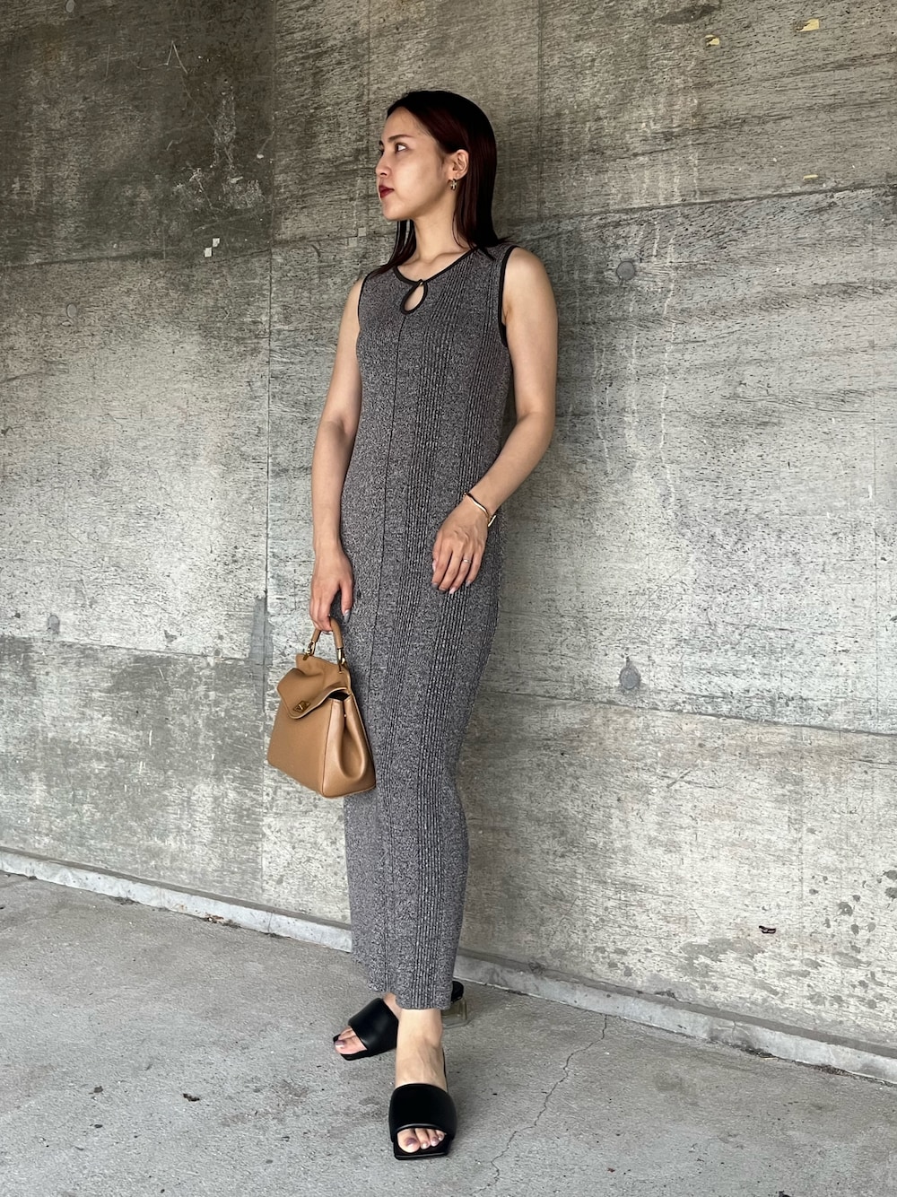 ブラック系のサンダル、グレー系のワンピース、ブラウン系のハンドバッグを着用したレディースの夏コーディネートの1枚目の写真