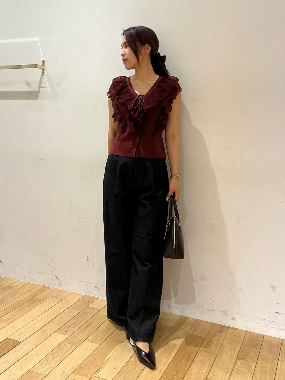 ブラック系のデニムパンツ、ブラウン系のパンプス、ブラウン系のボストンバッグを着用したレディースの夏コーディネートの1枚目の写真