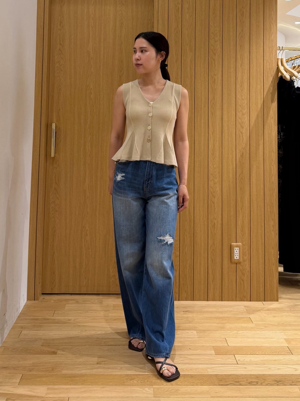 ブルー系のデニムパンツ、ベージュ系のニット/セーター、ブラウン系のサンダルを着用したレディースの夏コーディネートの1枚目の写真