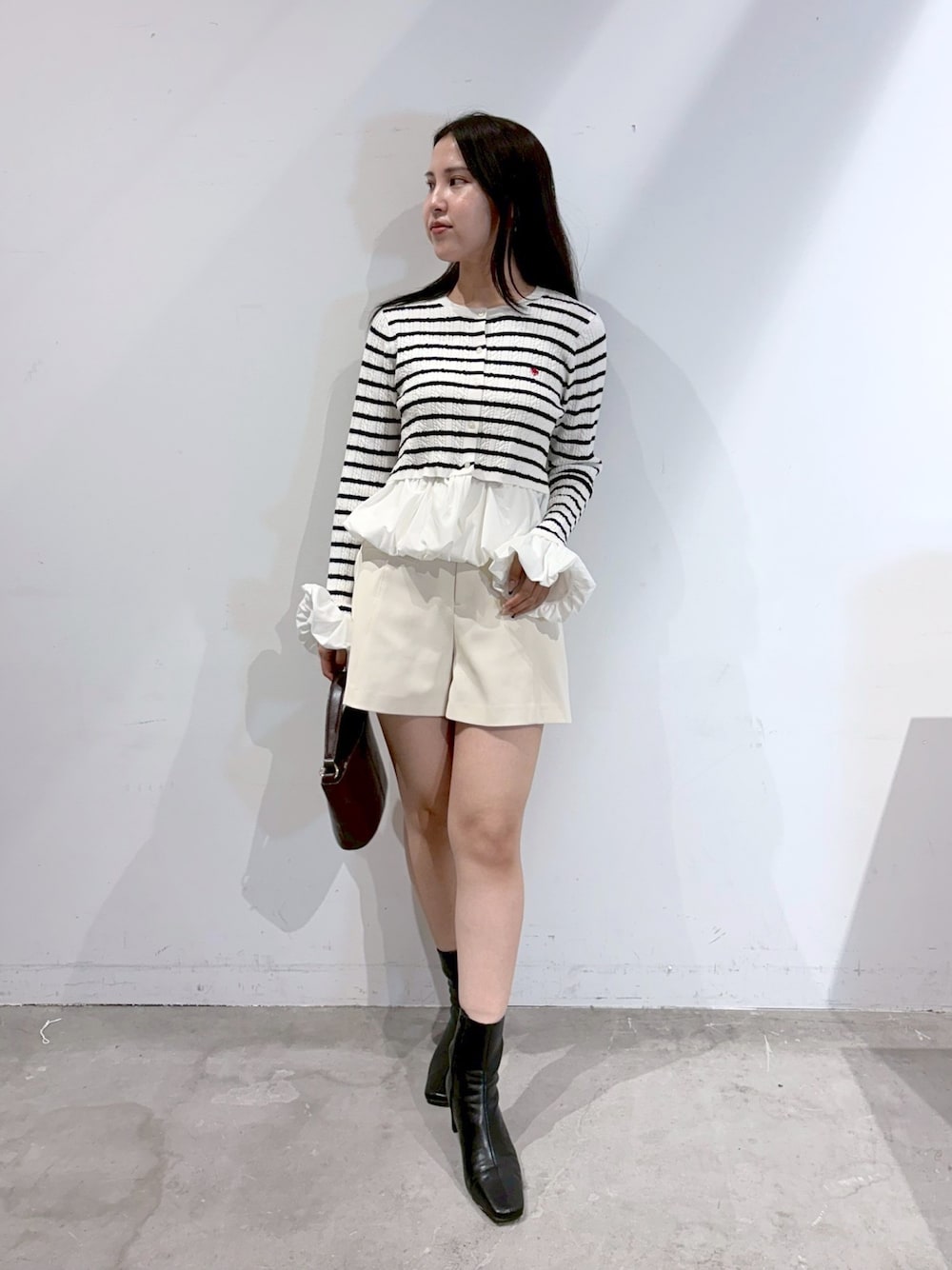 ホワイト系のその他パンツ、ブラック系のブーツ、ブラウン系のハンドバッグを着用したレディースの夏コーディネートの1枚目の写真
