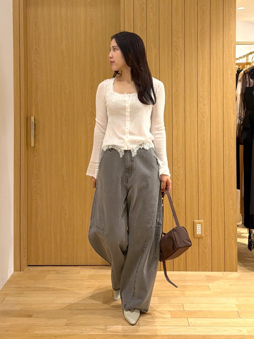ホワイト系のカーディガン/ボレロ、グレー系のデニムパンツ、ブラウン系のハンドバッグを着用したレディースの秋コーディネートの1枚目の写真