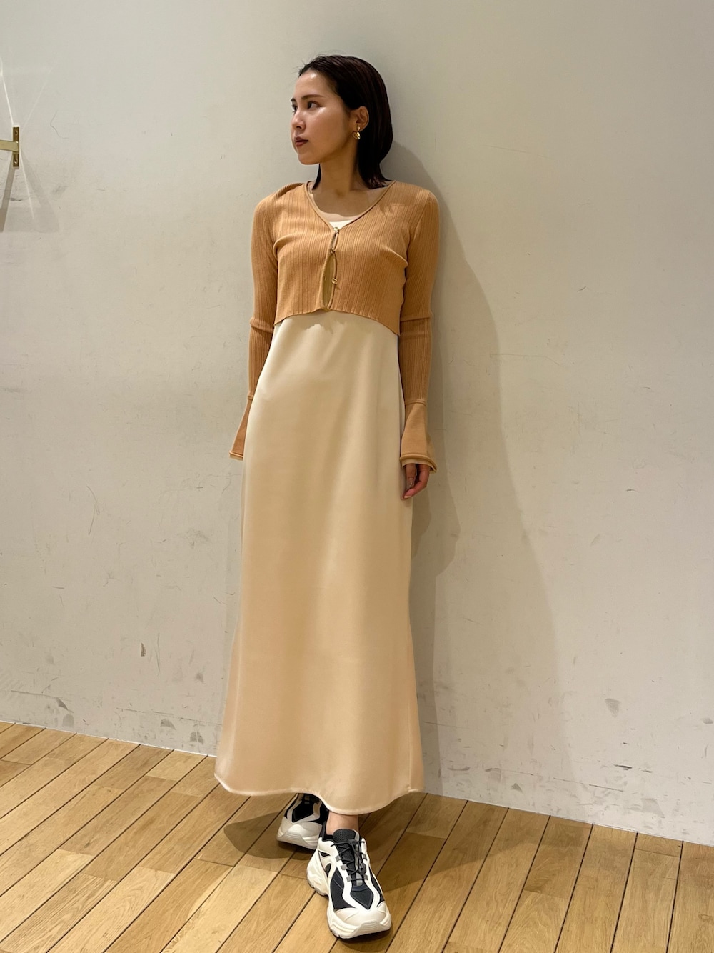 オレンジ系のワンピース、グレー系のスニーカーを着用したレディースの冬コーディネートの1枚目の写真