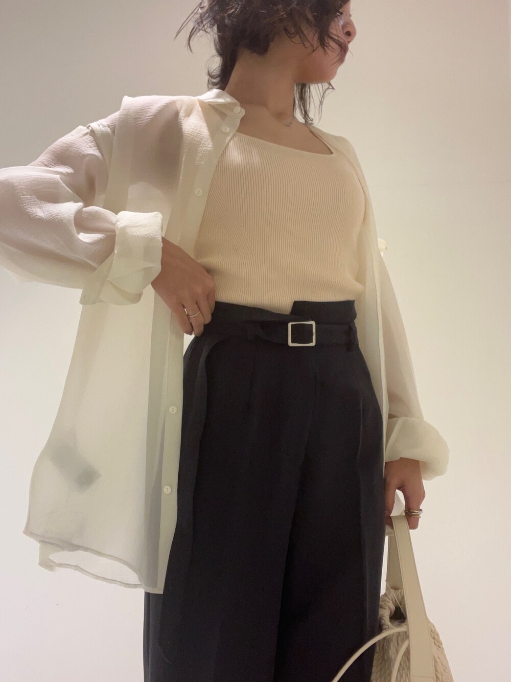 ホワイト系のハンドバッグ、その他のサンダル、ホワイト系のニット/セーターを着用したレディースの春コーディネートの1枚目の写真