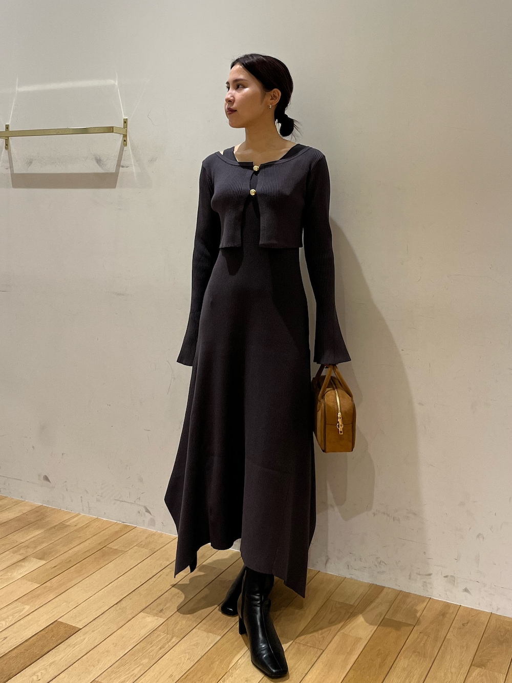 ブラック系のブーツ、グレー系のワンピース、ブラウン系のハンドバッグを着用したレディースの秋コーディネートの1枚目の写真