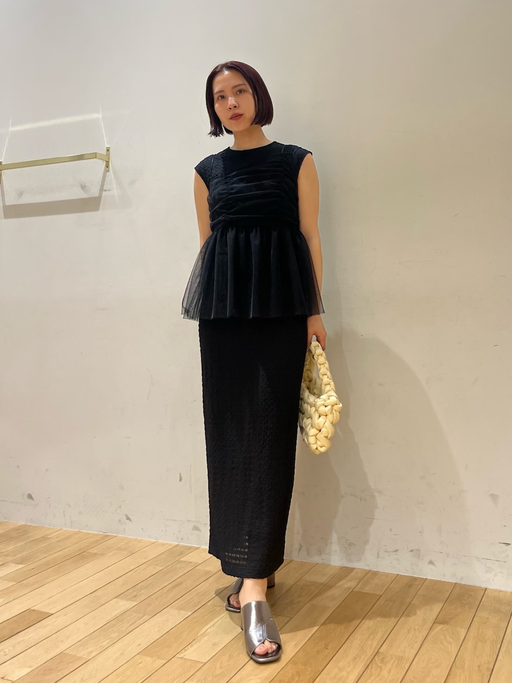 ホワイト系のハンドバッグ、ブラック系のワンピース、その他のサンダルを着用したレディースの夏コーディネートの1枚目の写真