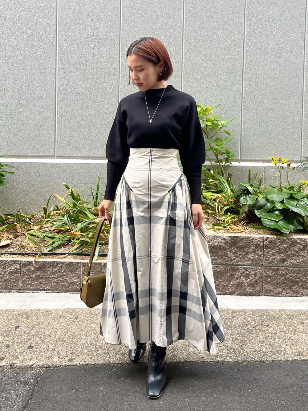 ホワイト系のワンピース、ブラック系のブーツ、ブラウン系のショルダーバッグを着用したレディースの冬コーディネートの1枚目の写真