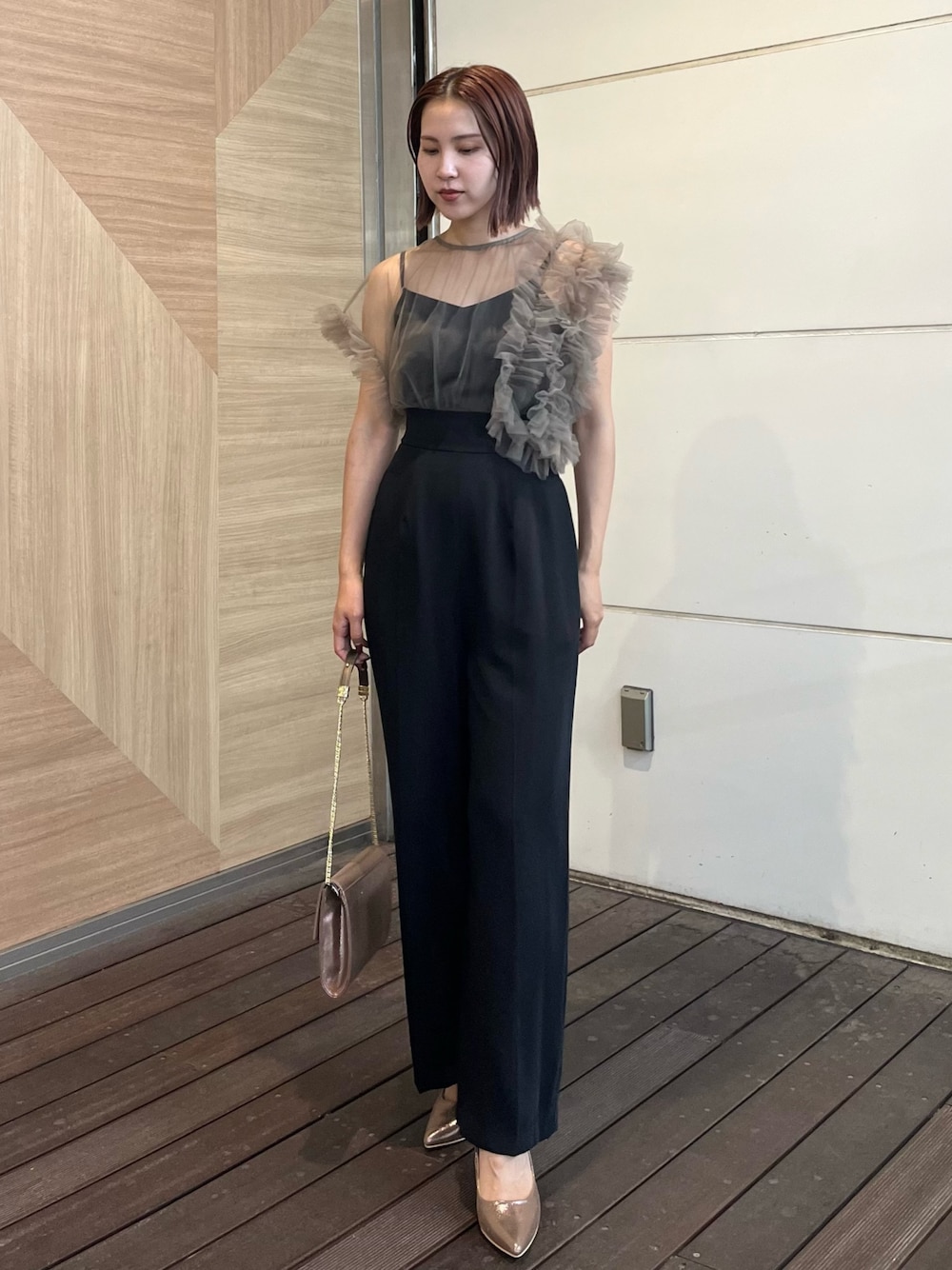 ゴールド系のハンドバッグ、ゴールド系のパンプス、その他のパンツドレスを着用したレディースの秋コーディネートの1枚目の写真