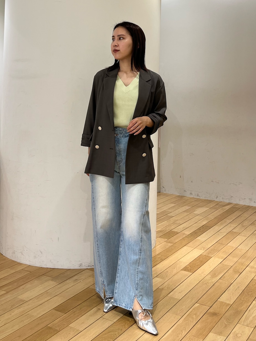 グレー系のテーラードジャケット、ブルー系のデニムパンツ、シルバー系のサンダルを着用したレディースの春コーディネートの1枚目の写真