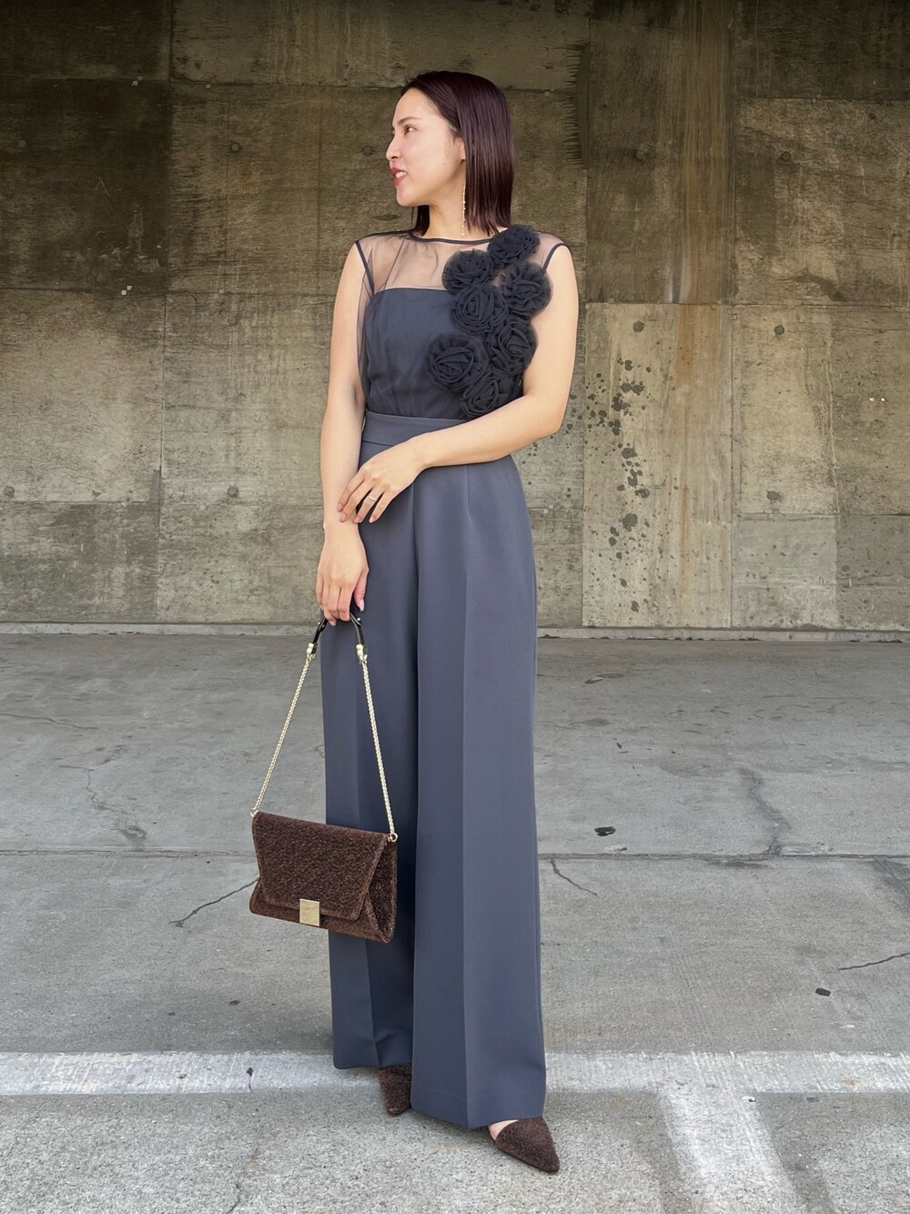 グレー系のパンツドレス、その他のクラッチバッグ、その他のパンプスを着用したレディースの冬コーディネートの1枚目の写真