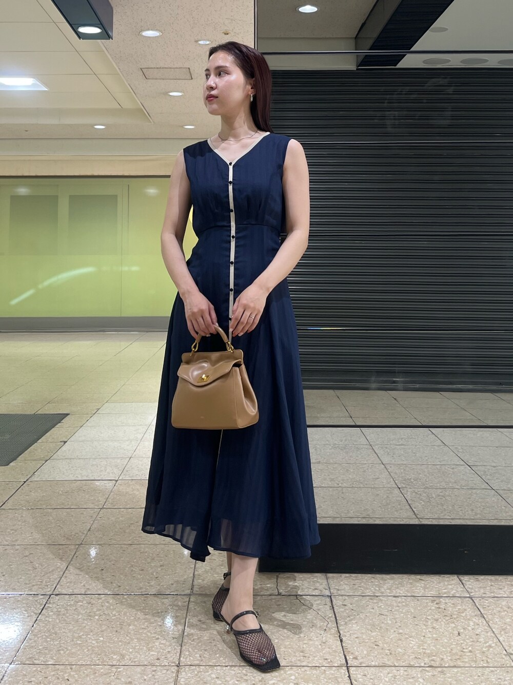 ブルー系のワンピース、ブラウン系のハンドバッグ、ブラック系のサンダルを着用したレディースの夏コーディネートの1枚目の写真