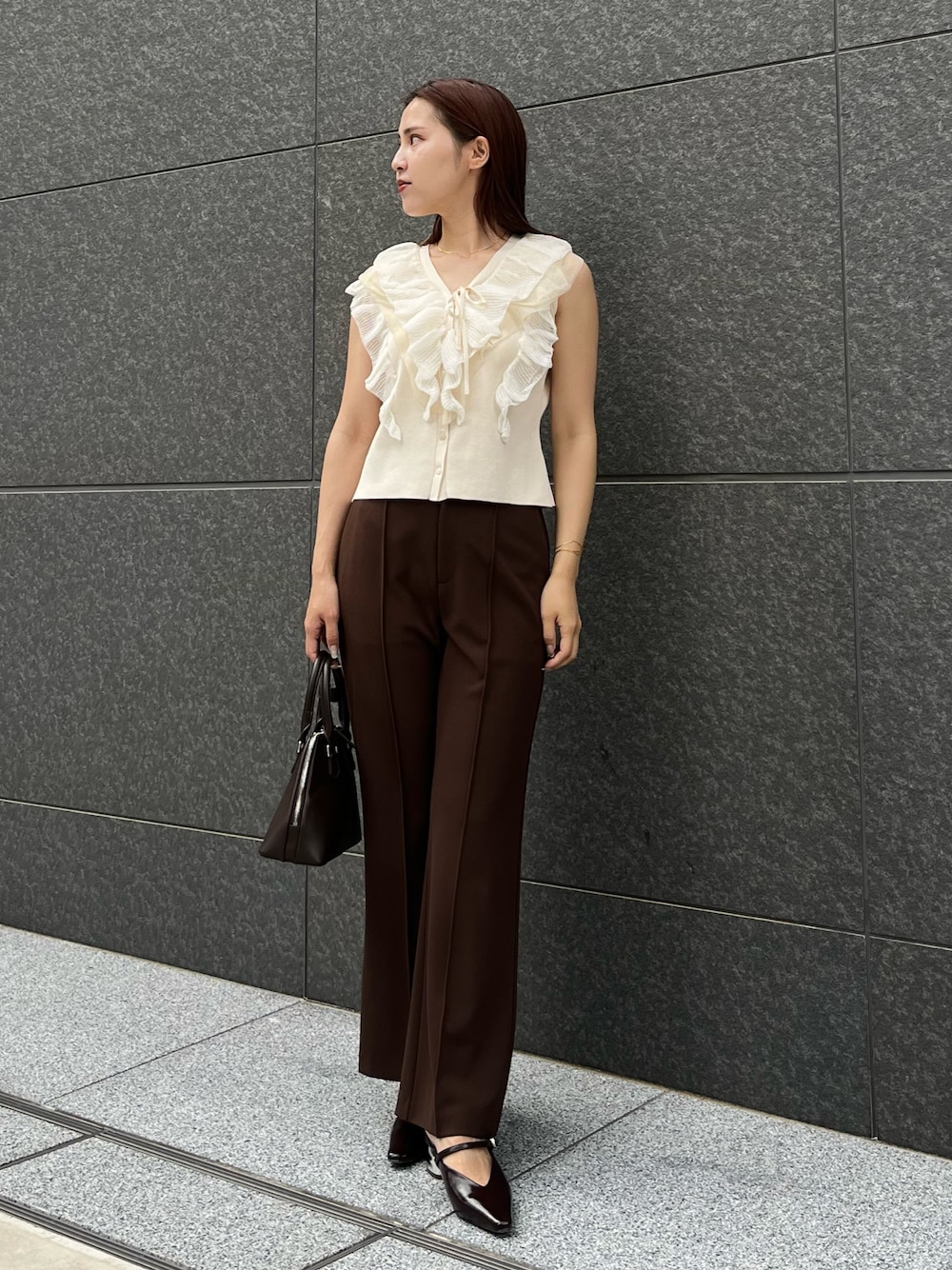 ホワイト系のニット/セーター、ブラウン系のその他パンツ、ブラウン系のボストンバッグを着用したレディースの夏コーディネートの1枚目の写真