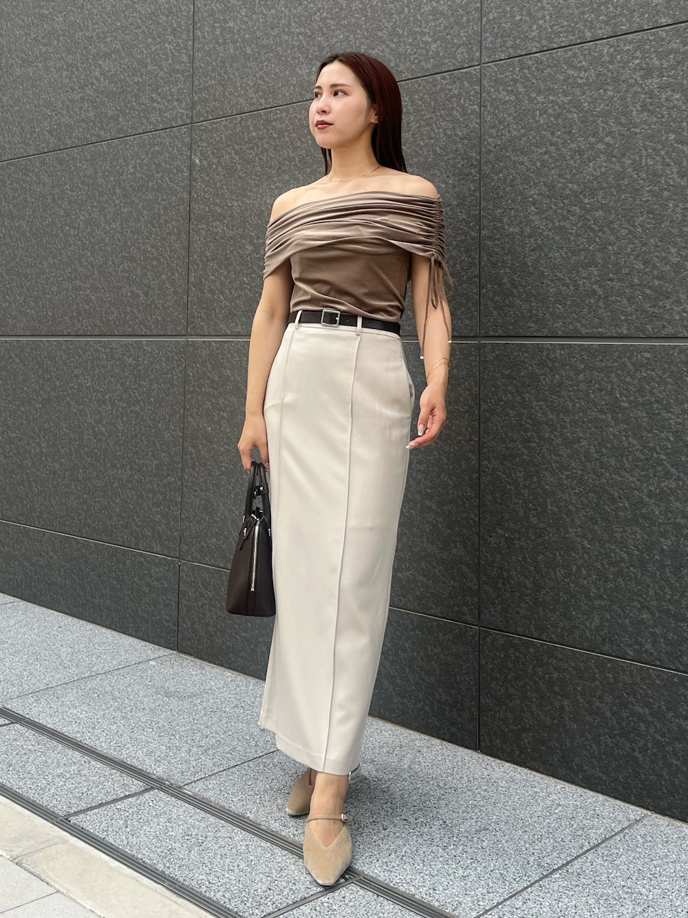 ベージュ系のパンプス、ブラウン系のボストンバッグ、ブラウン系のTシャツ/カットソーを着用したレディースの夏コーディネートの1枚目の写真