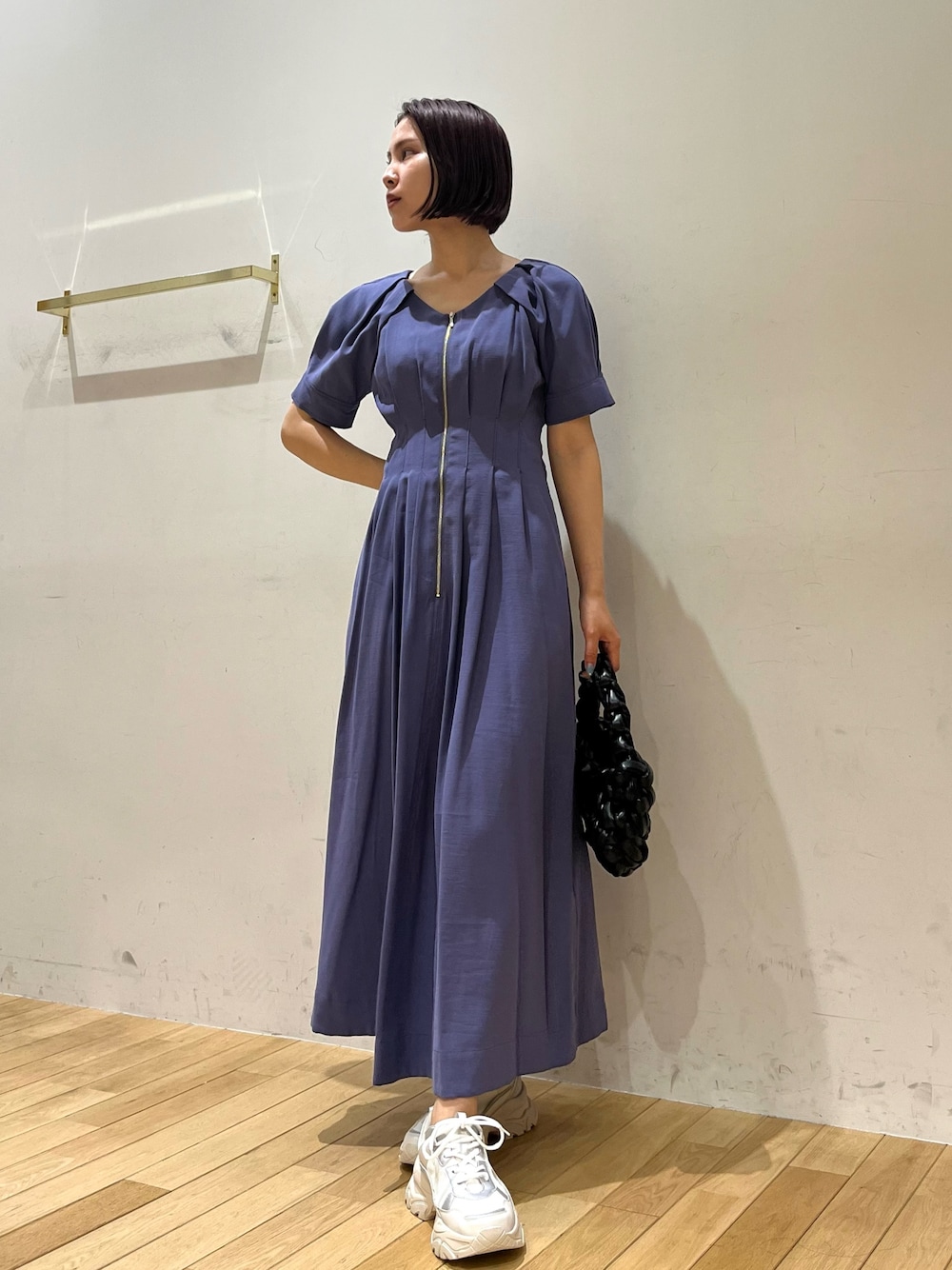 ブルー系のワンピース、ブラック系のハンドバッグ、ホワイト系のスニーカーを着用したレディースの夏コーディネートの1枚目の写真