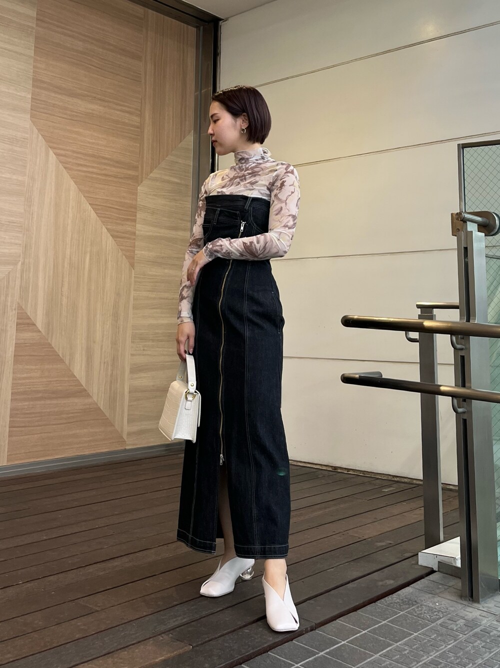 ホワイト系のパンプス、ホワイト系のショルダーバッグ、ブラック系のワンピースを着用したレディースの春コーディネートの1枚目の写真