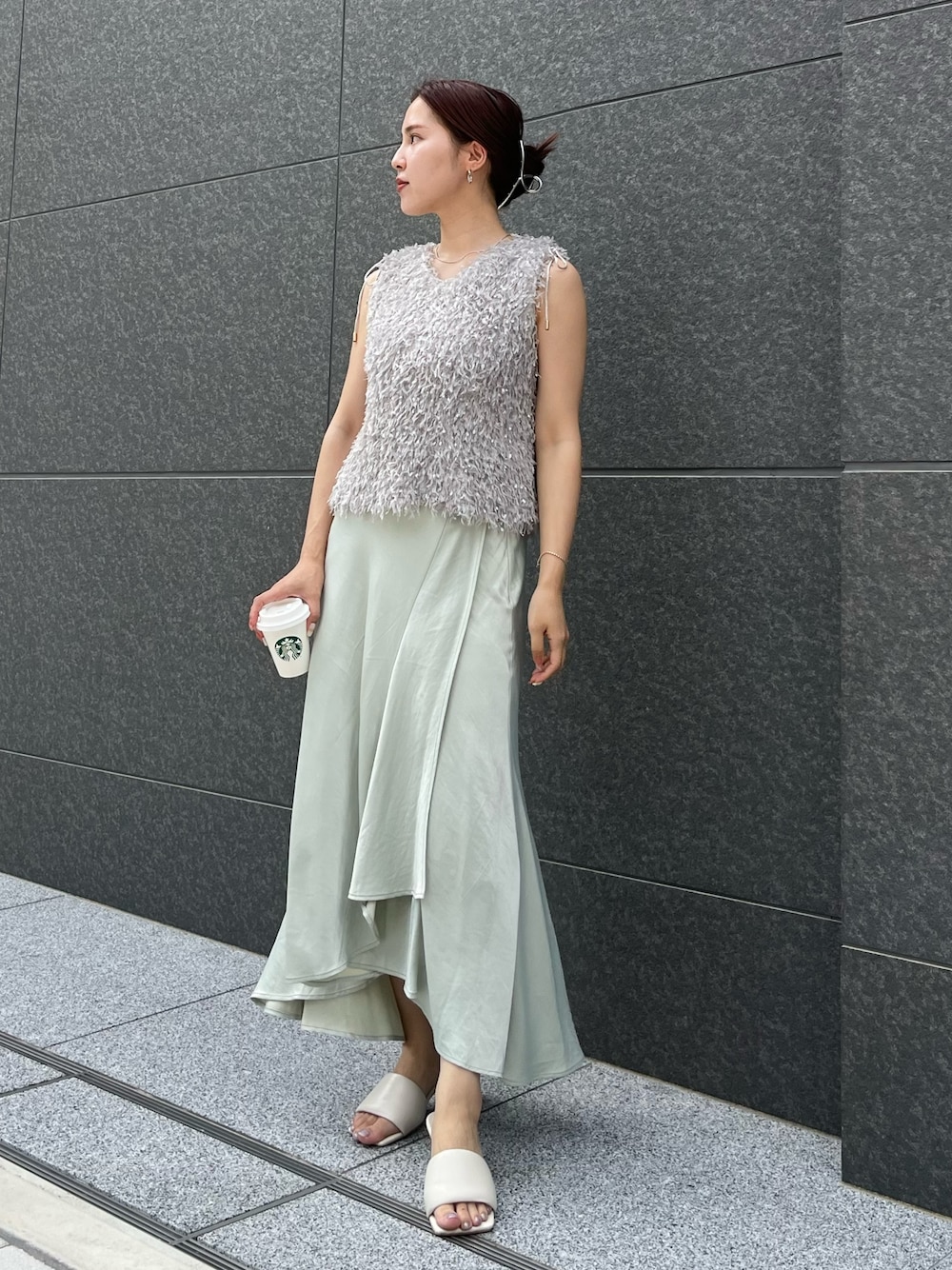 グレー系のTシャツ/カットソー、グリーン系のスカート、ホワイト系のサンダルを着用したレディースの夏コーディネートの1枚目の写真