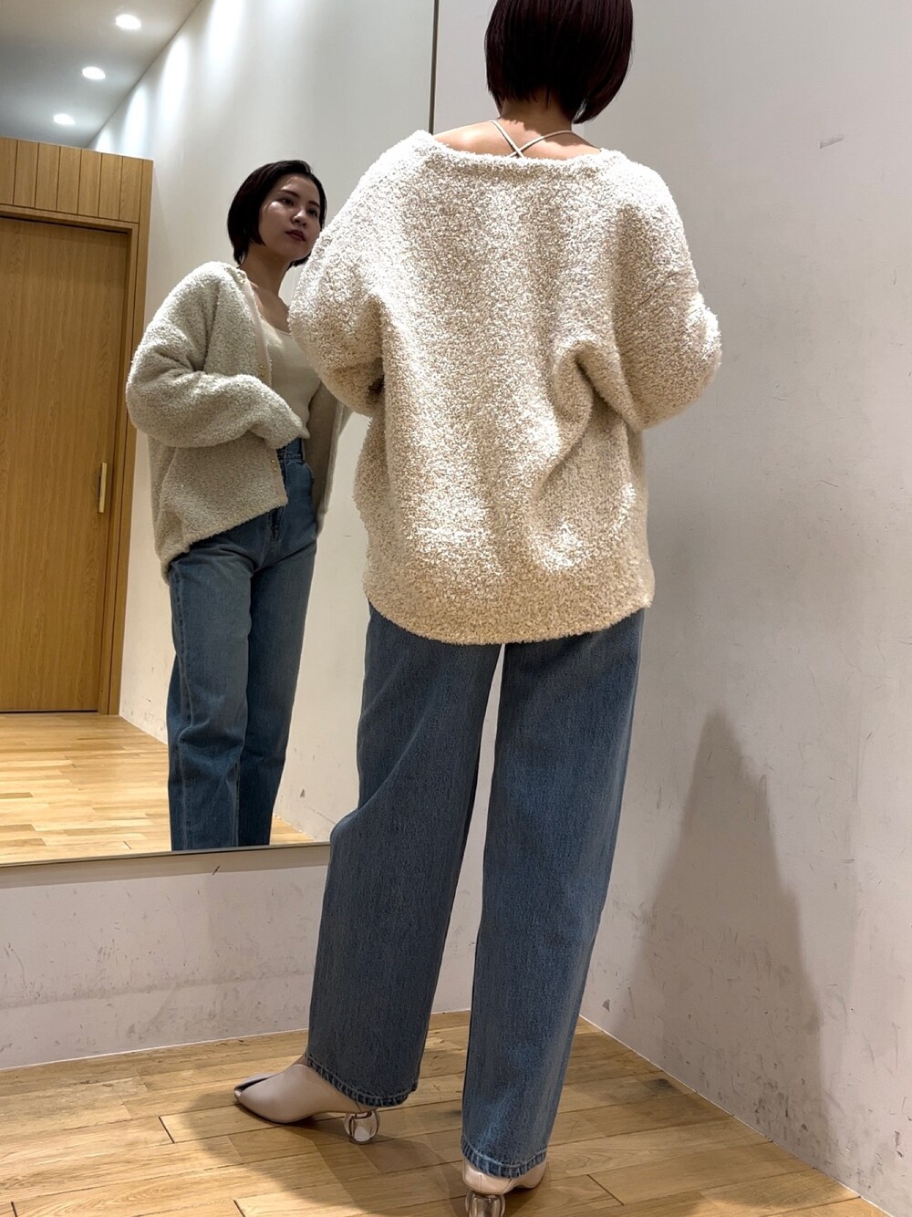 ホワイト系のパンプス、ブルー系のデニムパンツ、ホワイト系のニット/セーターを着用したレディースの冬コーディネートの1枚目の写真