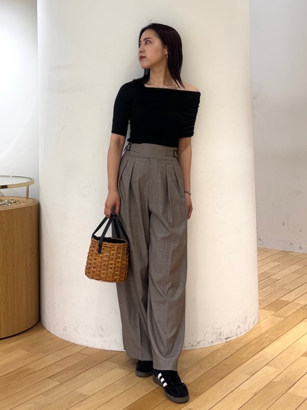 ブラウン系のハンドバッグ、ブラック系のスニーカー、ブラック系のTシャツ/カットソーを着用したレディースの夏コーディネートの1枚目の写真