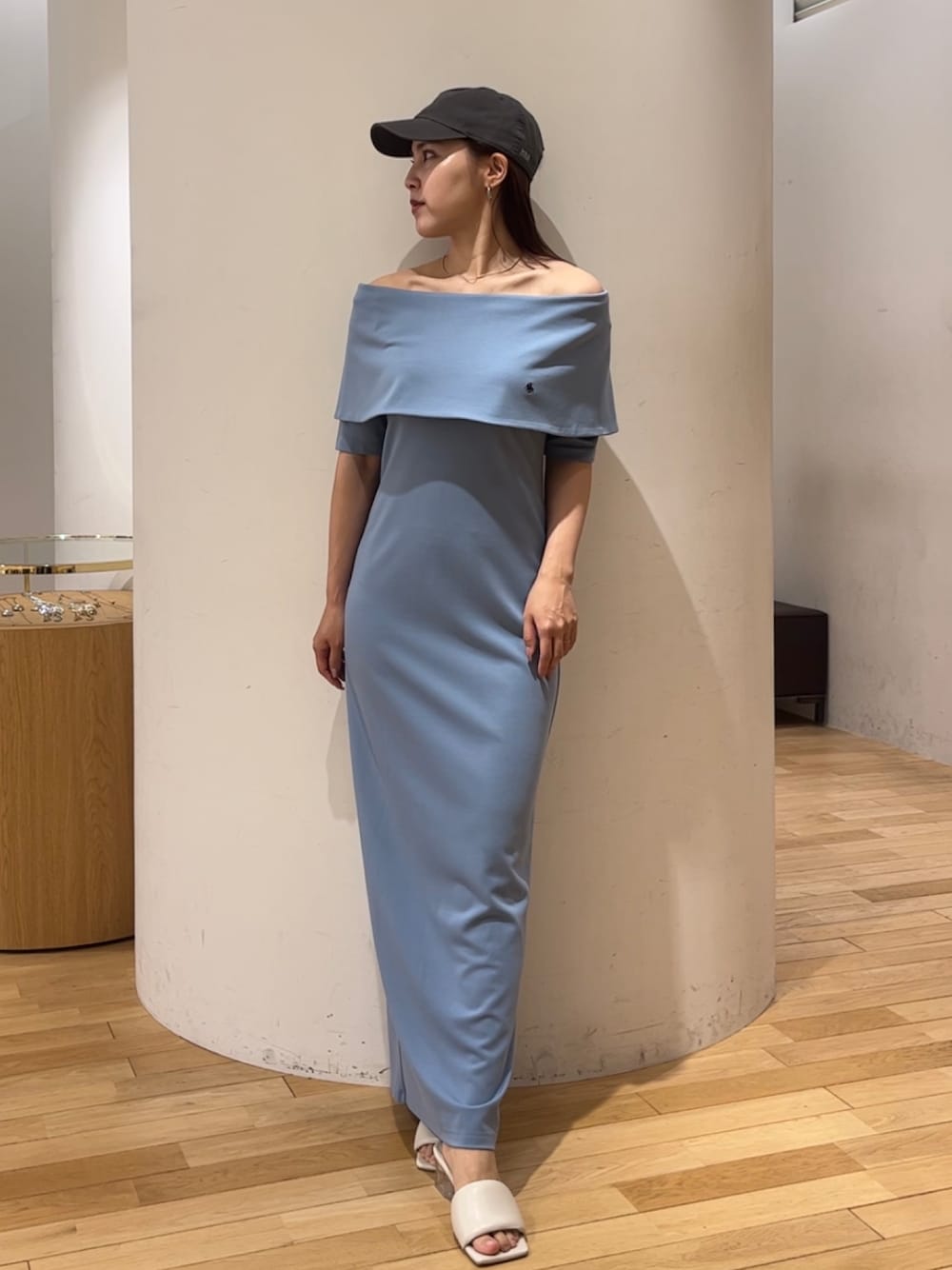 ブルー系のワンピース、ホワイト系のサンダル、グレー系のキャップを着用したレディースの春コーディネートの1枚目の写真