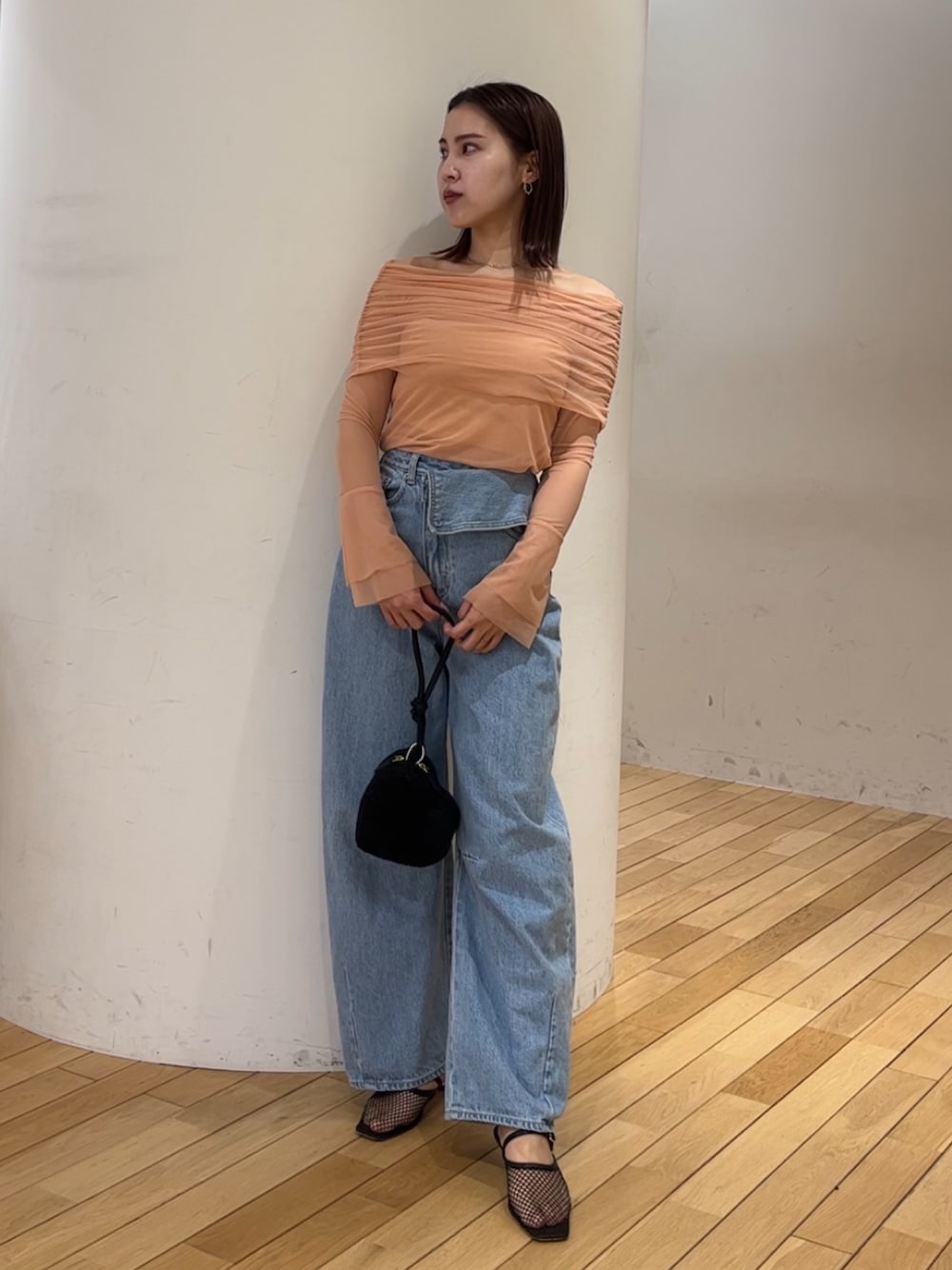 ブラック系のショルダーバッグ、ブラック系のサンダル、ブルー系のデニムパンツを着用したレディースの春コーディネートの1枚目の写真