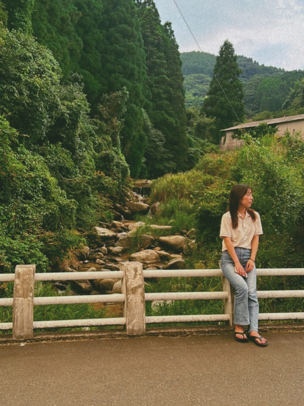 ホワイト系のトップス、ブルー系のデニムパンツ、ブラック系のサンダルを着用したレディースの冬コーディネートの1枚目の写真