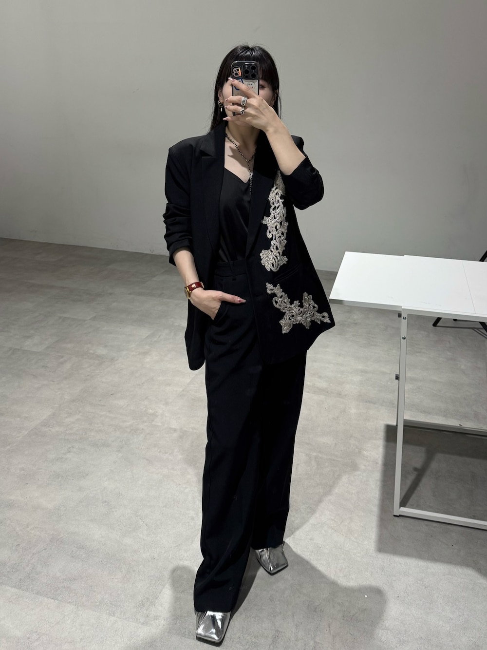 ブラック系のキャミソール、ブラック系のテーラードジャケットを着用したレディースの秋コーディネートの1枚目の写真