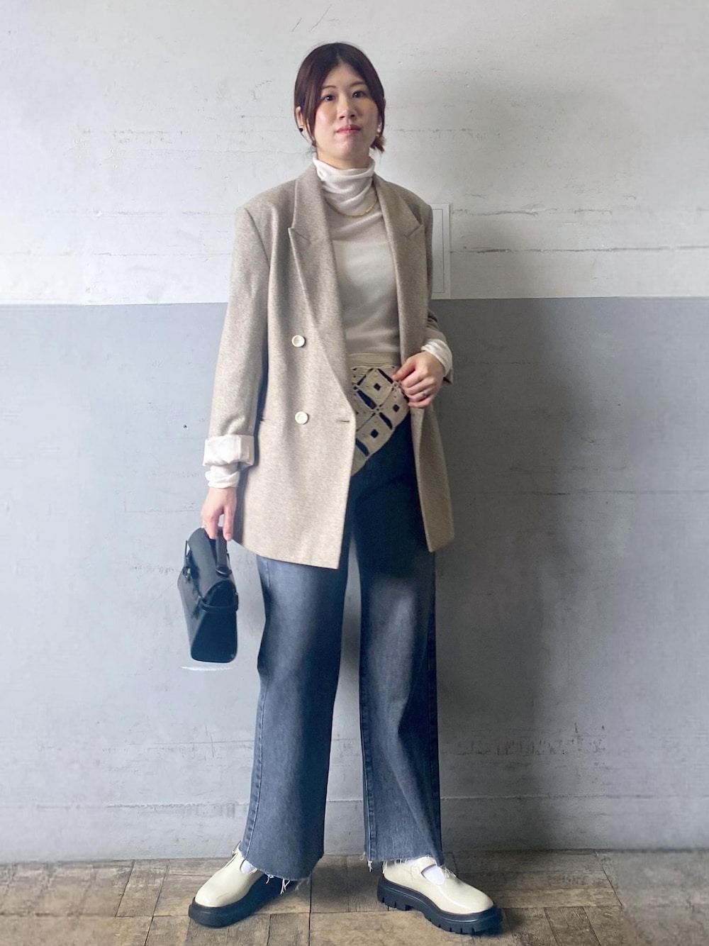 グレー系のデニムパンツ、ホワイト系のその他シューズ、ホワイト系のニット/セーターを着用したレディースの秋コーディネートの1枚目の写真