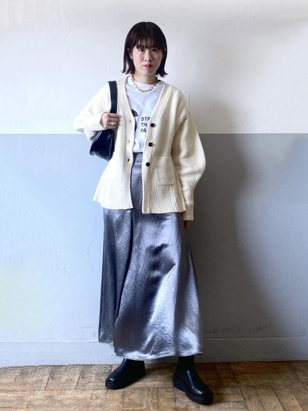 ホワイト系のTシャツ/カットソー、ブラック系のブーツ、ホワイト系のカーディガン/ボレロを着用したレディースの冬コーディネートの1枚目の写真