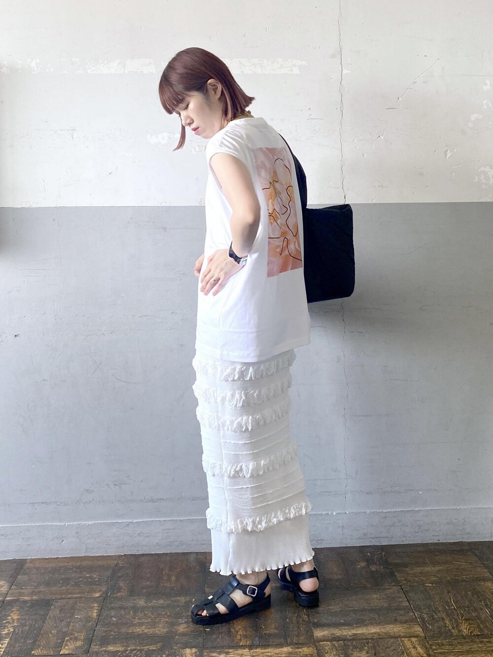 ブラック系のサンダル、ホワイト系のスカート、ホワイト系のTシャツ/カットソーを着用したレディースの夏コーディネートの1枚目の写真
