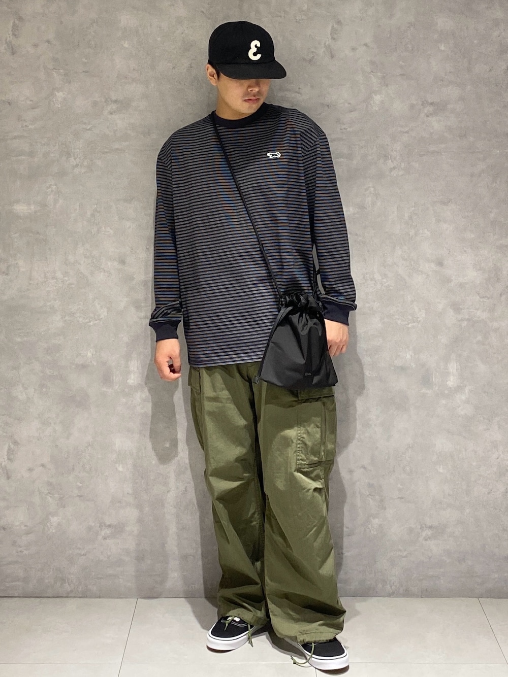 ブラック系のTシャツ/カットソー、ブラック系のショルダーバッグ、グリーン系のその他パンツを着用したメンズの秋コーディネートの1枚目の写真