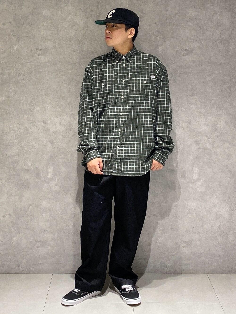 グリーン系のシャツ/ブラウス、ブラック系のチノパンツ、ブラック系のスニーカーを着用したメンズの秋コーディネートの1枚目の写真