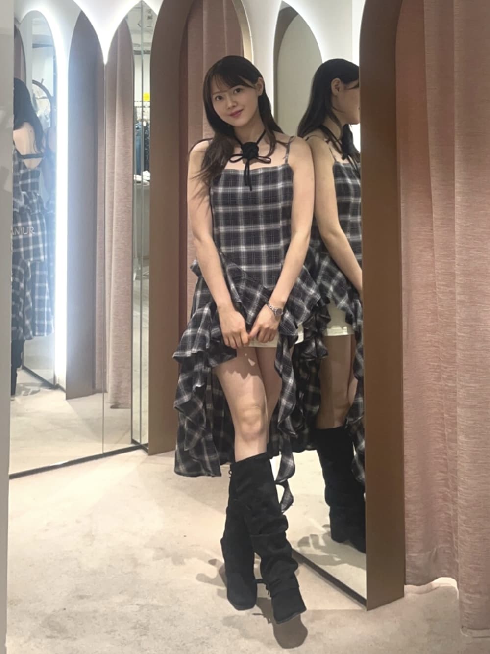 ブラック系のワンピース、ホワイト系のスカート、ブラック系のブーツを着用したレディースの夏コーディネートの1枚目の写真