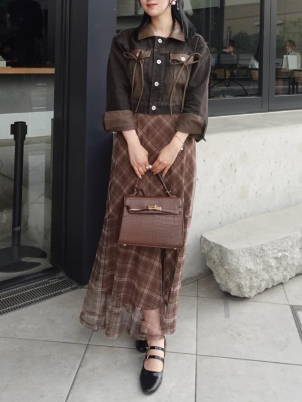 ブラック系のデニムジャケットを着用したレディースの秋コーディネートの1枚目の写真