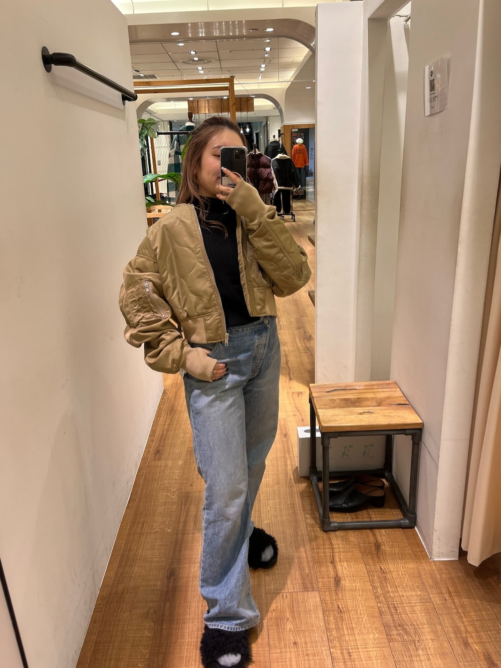 ブラック系のニット/セーター、ブルー系のデニムパンツ、ベージュ系のブルゾンを着用したレディースの秋コーディネートの1枚目の写真