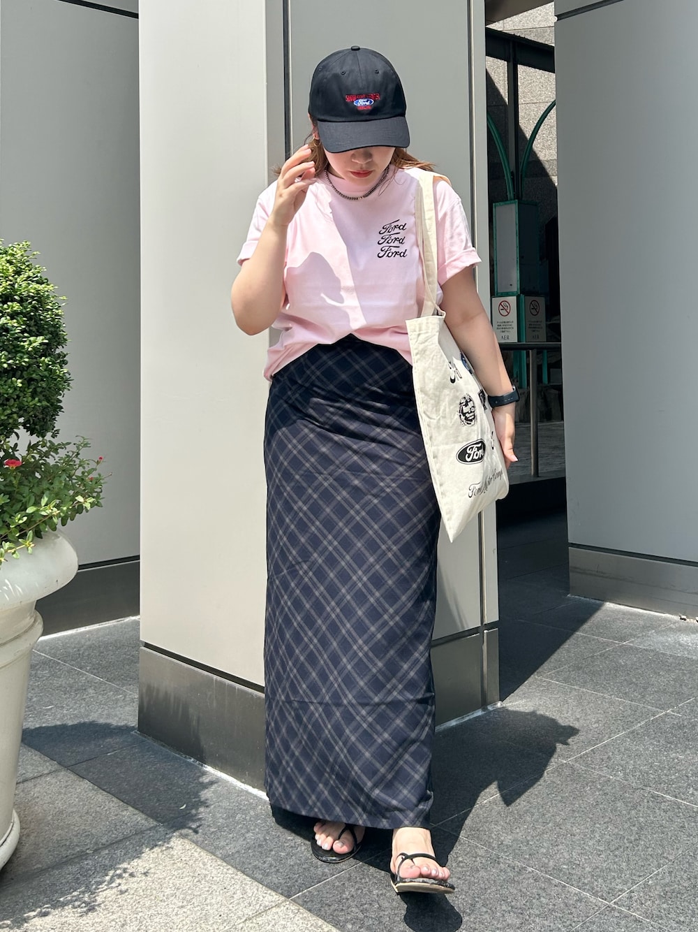 ブルー系のスカート、ピンク系のTシャツ/カットソー、ホワイト系のトートバッグを着用したレディースの夏コーディネートの1枚目の写真