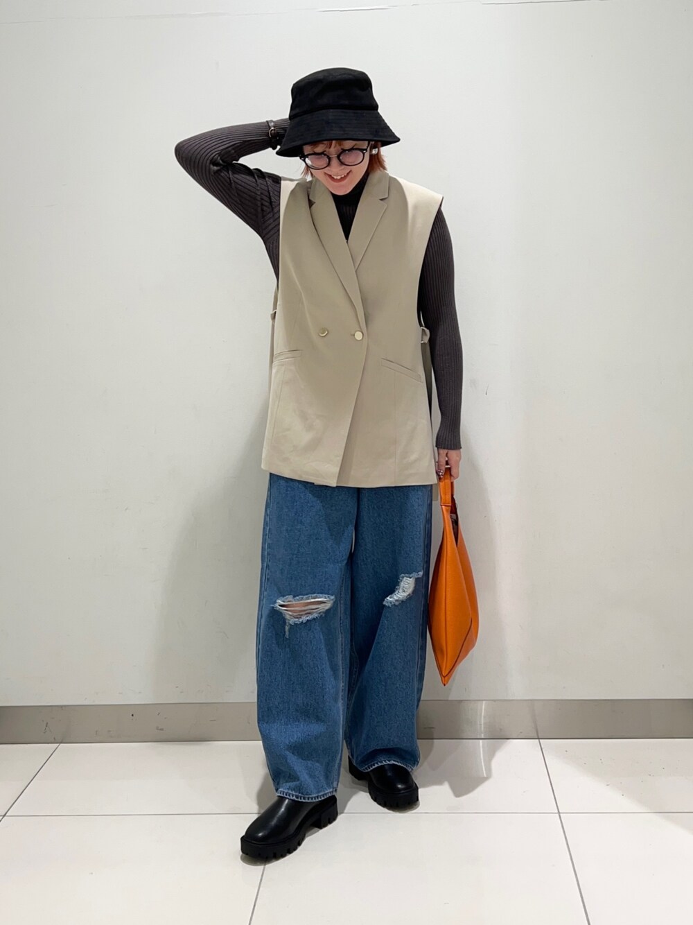 ベージュ系のジャケット/アウター、グレー系のニット/セーター、ブラック系のブーツを着用したレディースの秋コーディネートの1枚目の写真
