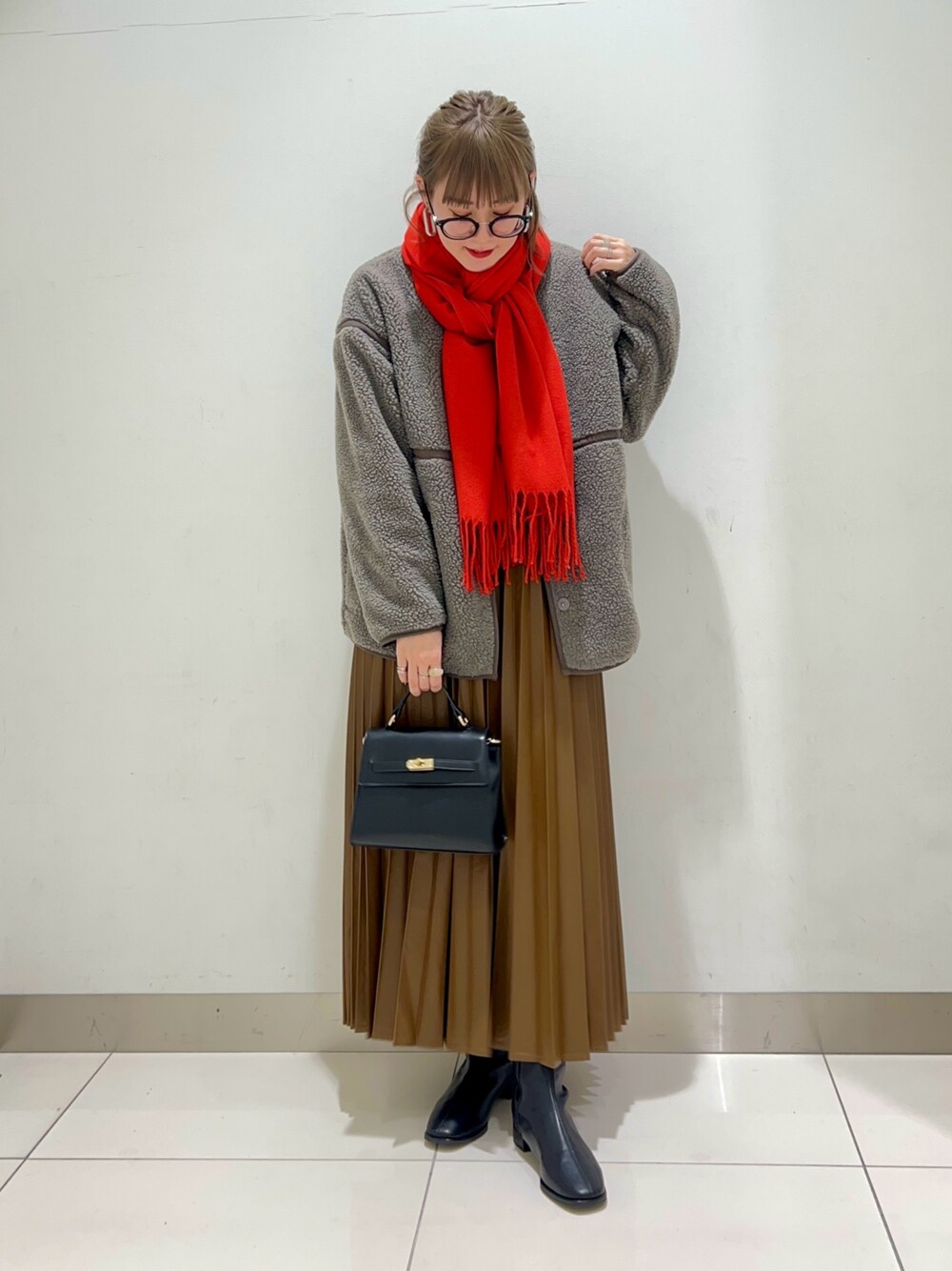 ブラック系のブーツ、ブラウン系のスカート、グレー系のその他アウターを着用したレディースの秋コーディネートの1枚目の写真