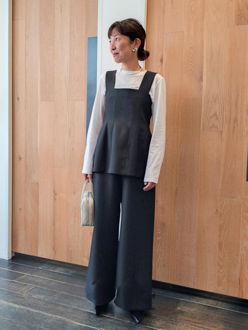 ホワイト系のハンドバッグを着用したレディースの冬コーディネートの1枚目の写真