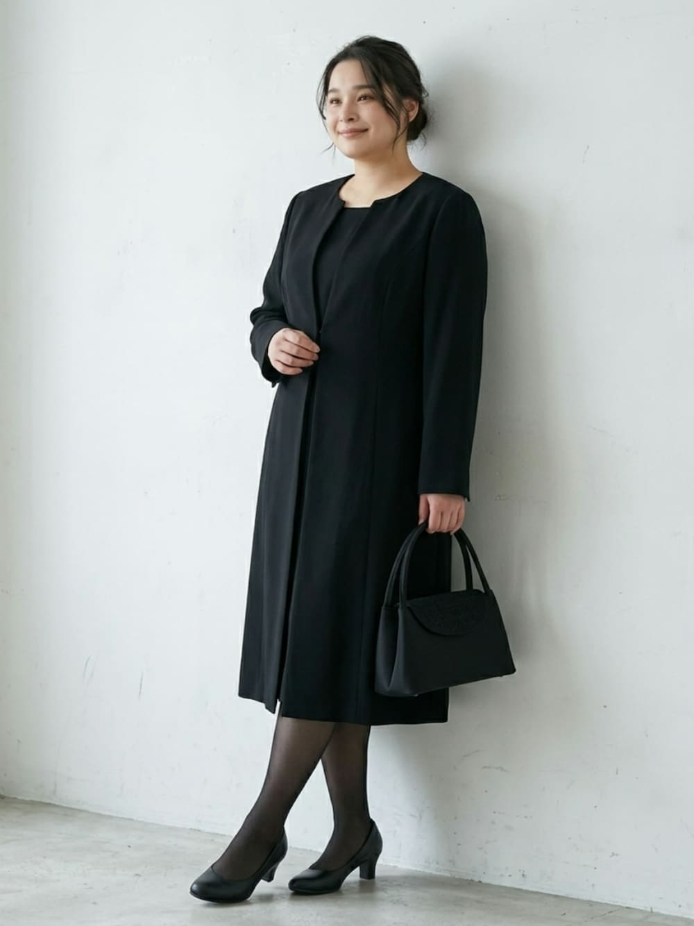 ブラック系のパンプス、ブラック系のバッグ、ブラック系のフォーマルスーツ/小物を着用したレディースの秋コーディネートの1枚目の写真
