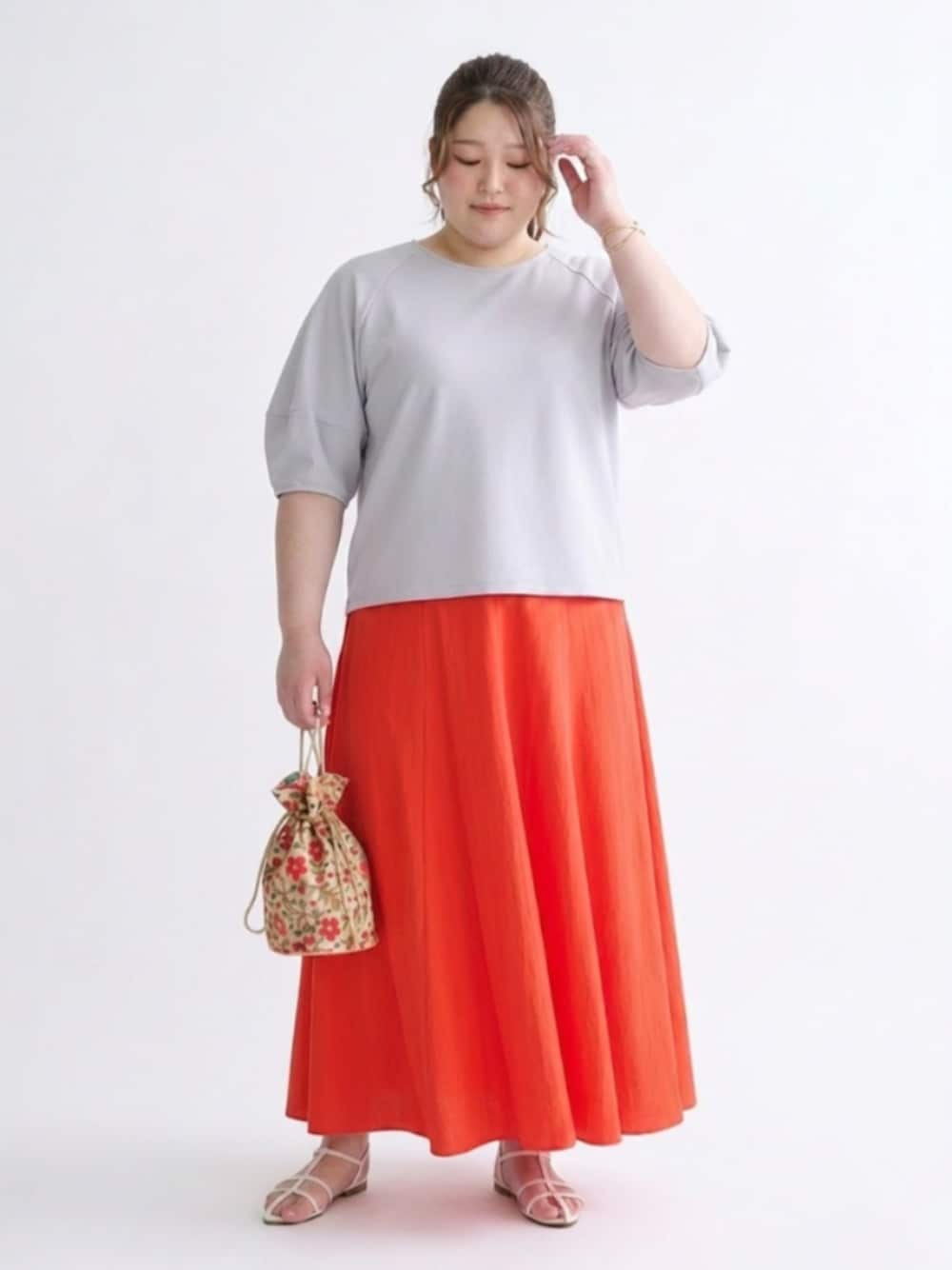グレー系のTシャツ/カットソー、オレンジ系のスカートを着用したレディースの春コーディネートの1枚目の写真