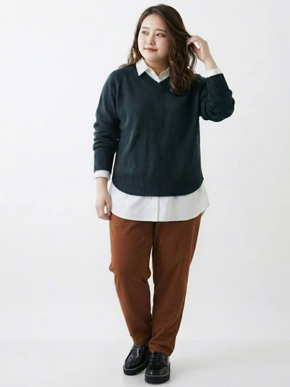 ブラック系のニット/セーター、ホワイト系のシャツ/ブラウス、ブラウン系のパンツを着用したレディースの冬コーディネートの1枚目の写真