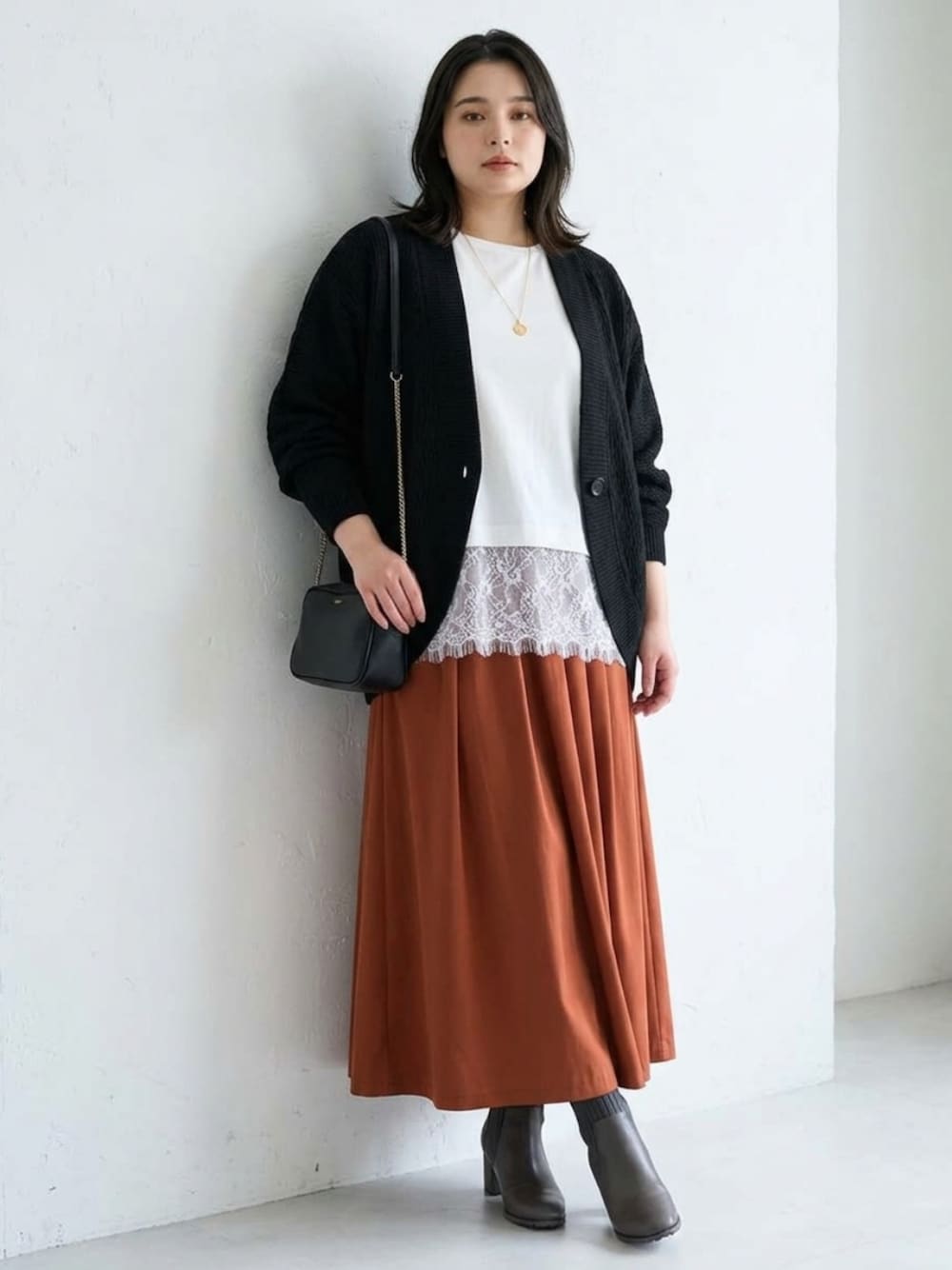 ホワイト系のTシャツ/カットソー、ブラック系のカーディガン/ボレロ、ブラウン系のスカートを着用したレディースの秋コーディネートの1枚目の写真