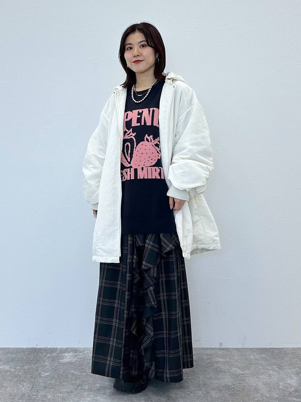 ブラック系のスニーカー、ホワイト系のブルゾン、ブルー系のニット/セーターを着用したレディースの秋コーディネートの1枚目の写真