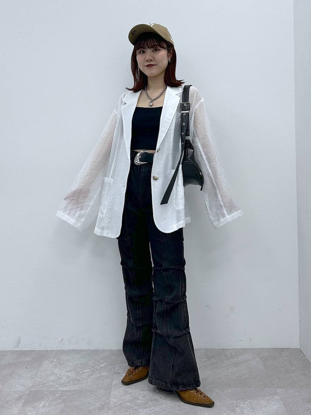 ブラウン系のパンプス、ブラック系のショルダーバッグ、ブラック系のデニムパンツを着用したレディースの春コーディネートの1枚目の写真