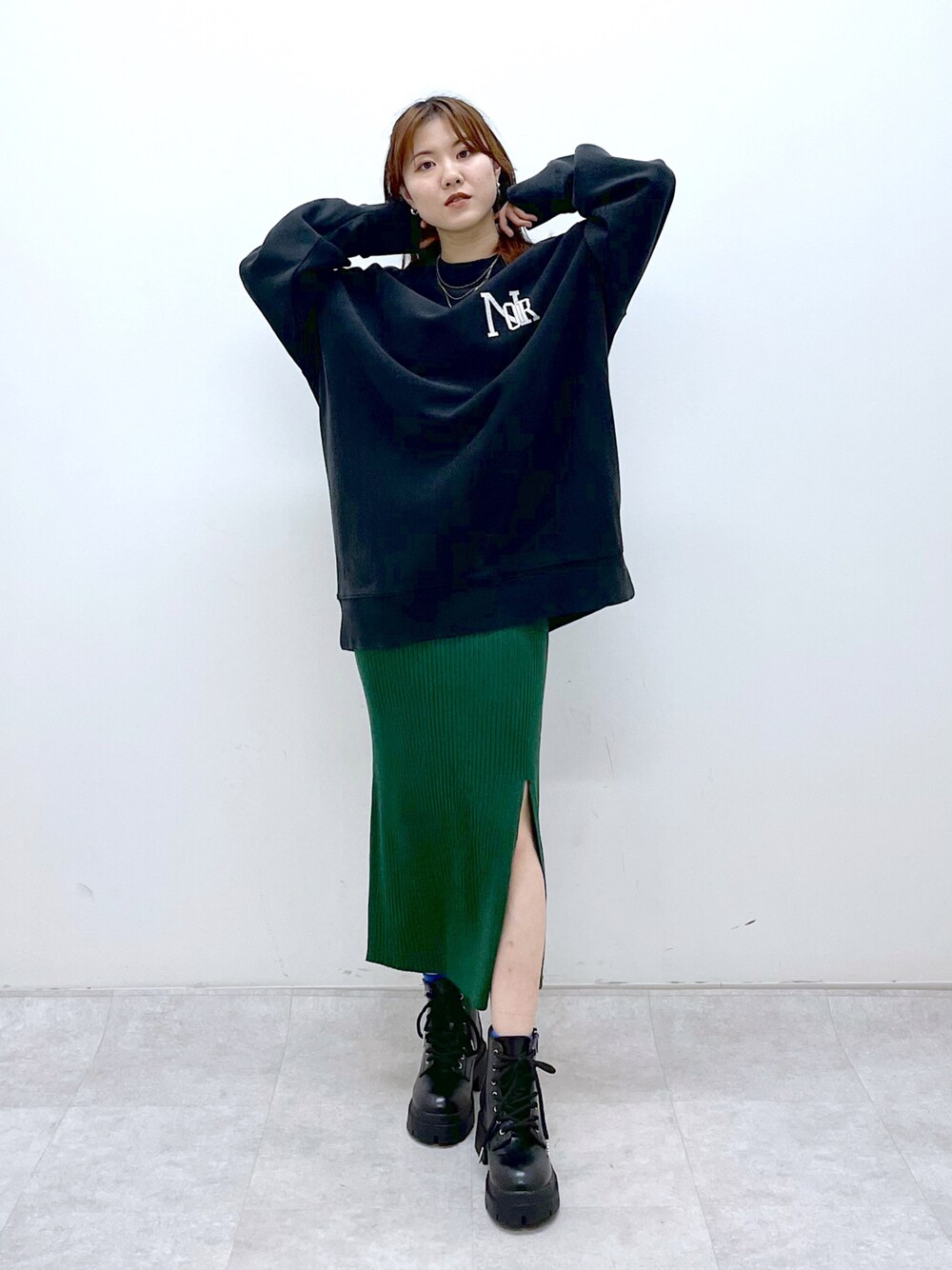 ブラック系のスウェット、グリーン系のワンピース、ブラック系のブーツを着用したレディースの冬コーディネートの1枚目の写真