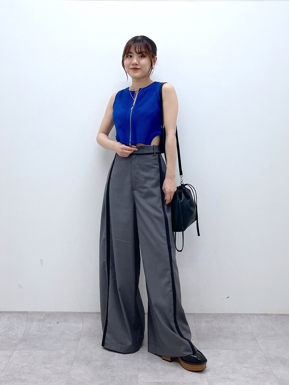 ブルー系のタンクトップ、グレー系のスラックス、ブラック系のローファーを着用したレディースの夏コーディネートの1枚目の写真